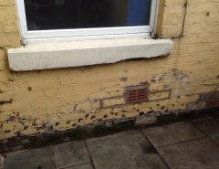 External brick wall showing an air brick for sub floor ventilation