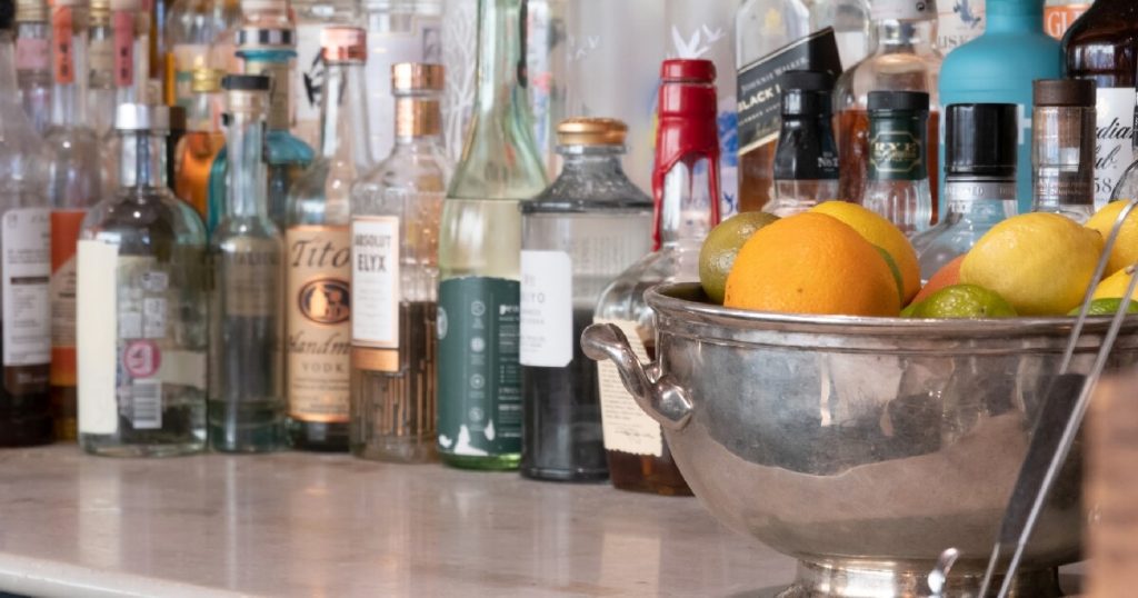 bar-counter-with-bottles-and-citrus-fruits-in-bowl-attracting-fruit-flies