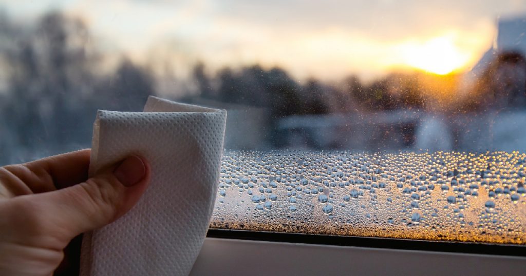 property-care-wiping-condensation-from-window-close-up